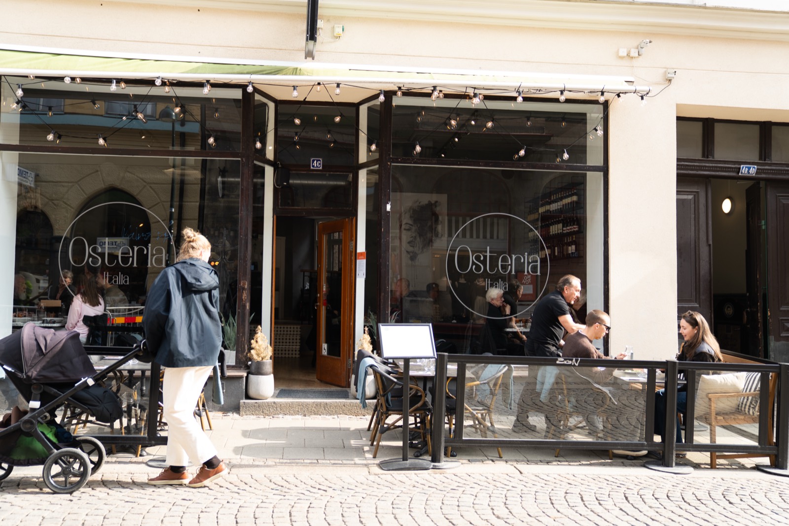 The Osteria Italia storefront on a busy afternoon.